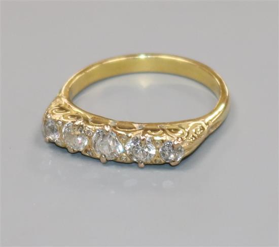 A yellow metal and graduated five stone diamond half hoop ring, size N.